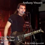 Anthony performing live, guitar in hand, fire in his expression.