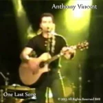 Anthony under bright yellow lights, acoustic guitar in hand.